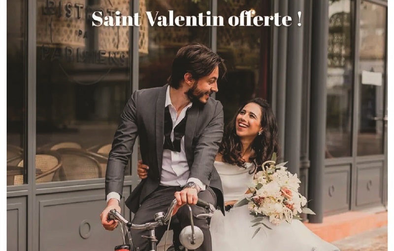 Un couple souriant en tenue de mariage, évoquant la complicité et le bonheur, devant une vitrine parisienne, idéal pour illustrer la recherche d'un nid d'amour avec notre agence de chasse immobilière à Paris