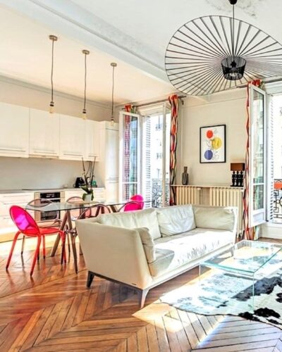 Salon lumineux et moderne d’un pied-à-terre de charme avec balcon situé dans le quartier du Marais à Paris