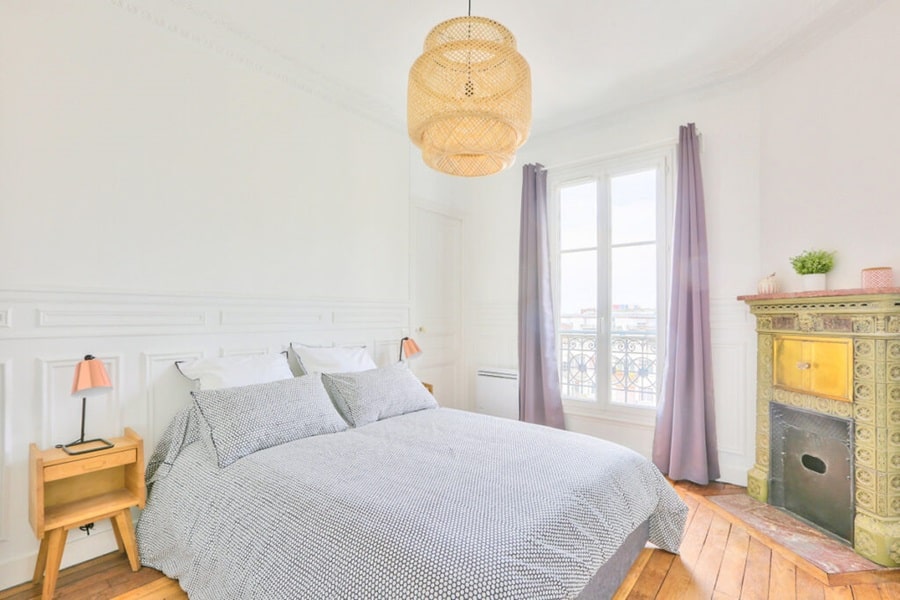 Chambre spacieuse et lumineuse avec une cheminée en faïence et une vue dégagée, située près de la mairie d’Asnières-sur-Seine, idéale pour un investissement locatif.