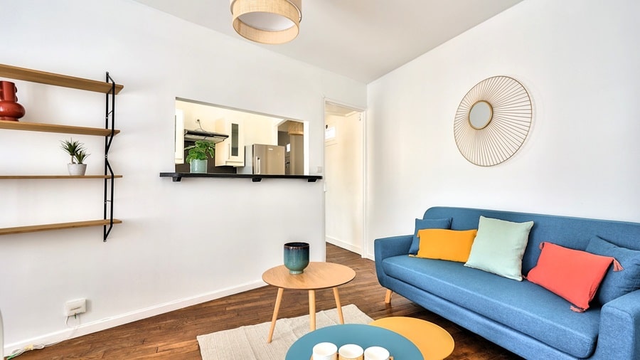 Cuisine compacte et optimisée avec plan de travail en bois et rangements intégrés, dans un appartement deux pièces situé à Bois-Colombes, au pied du tram, proposé par un chasseur immobilier dans les Hauts-de-Seine.