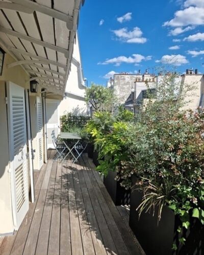 Terrasse arborée avec vue dégagée d’un appartement situé rue de Verneuil, Paris 7e, offrant un cadre paisible et lumineux.