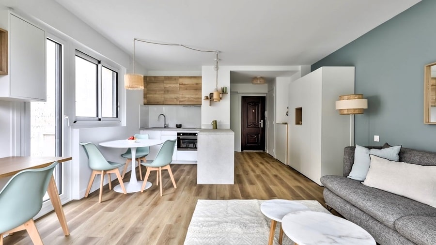 Salon moderne avec cuisine ouverte et salle à manger, dans un appartement clé en main à Paris, parfait pour l'investissement locatif.