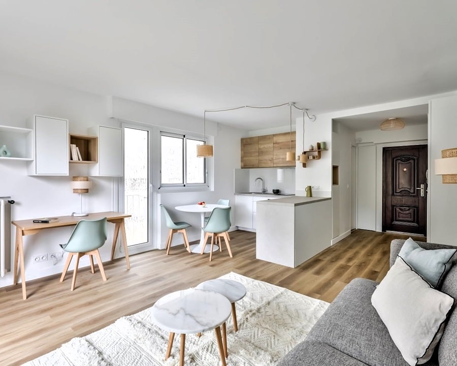Studio moderne et lumineux à Paris 5e, doté d’un espace ouvert avec coin bureau, cuisine équipée, et coin repas, parquet clair et décoration épurée.