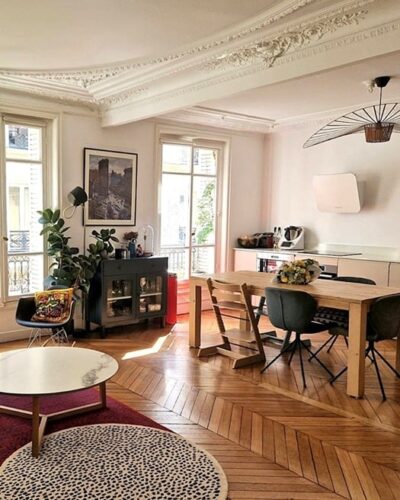 Appartement lumineux avec moulures d'époque, parquet en chevrons et double exposition, situé cité Trévise dans le 9e arrondissement de Paris. Espace salon-salle à manger élégant et chaleureux avec des touches de décoration contemporaine
