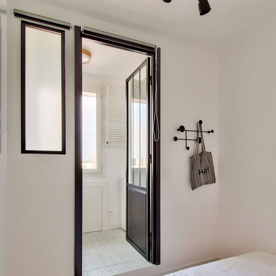 Salle d'eau moderne avec douche, verrière noire, et lavabo design dans un 2 pièces à Asnières proche du métro, proposé par Early Birds chasseurs immobiliers.