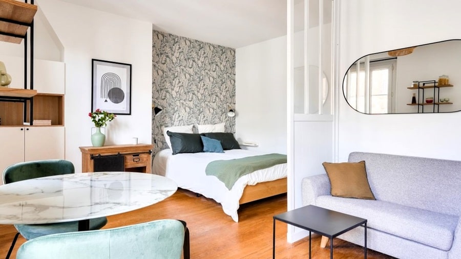 Chambre avec lit double, papier peint design et rangement intégré, parfaite pour un investissement locatif à Paris 14.
