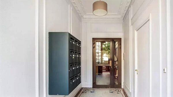 Hall d’entrée lumineux et raffiné d’un immeuble aux Allées Gambetta à Clichy (92), avec boîtes aux lettres modernes et moulures classiques