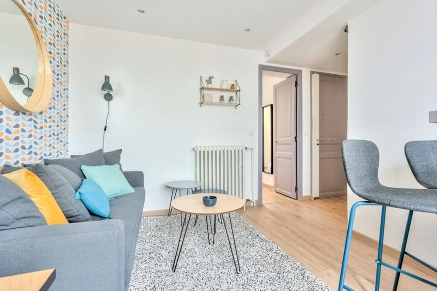 Salon lumineux avec canapé, table basse et décoration moderne dans un appartement à Colombes, conçu pour un investissement locatif rentable
