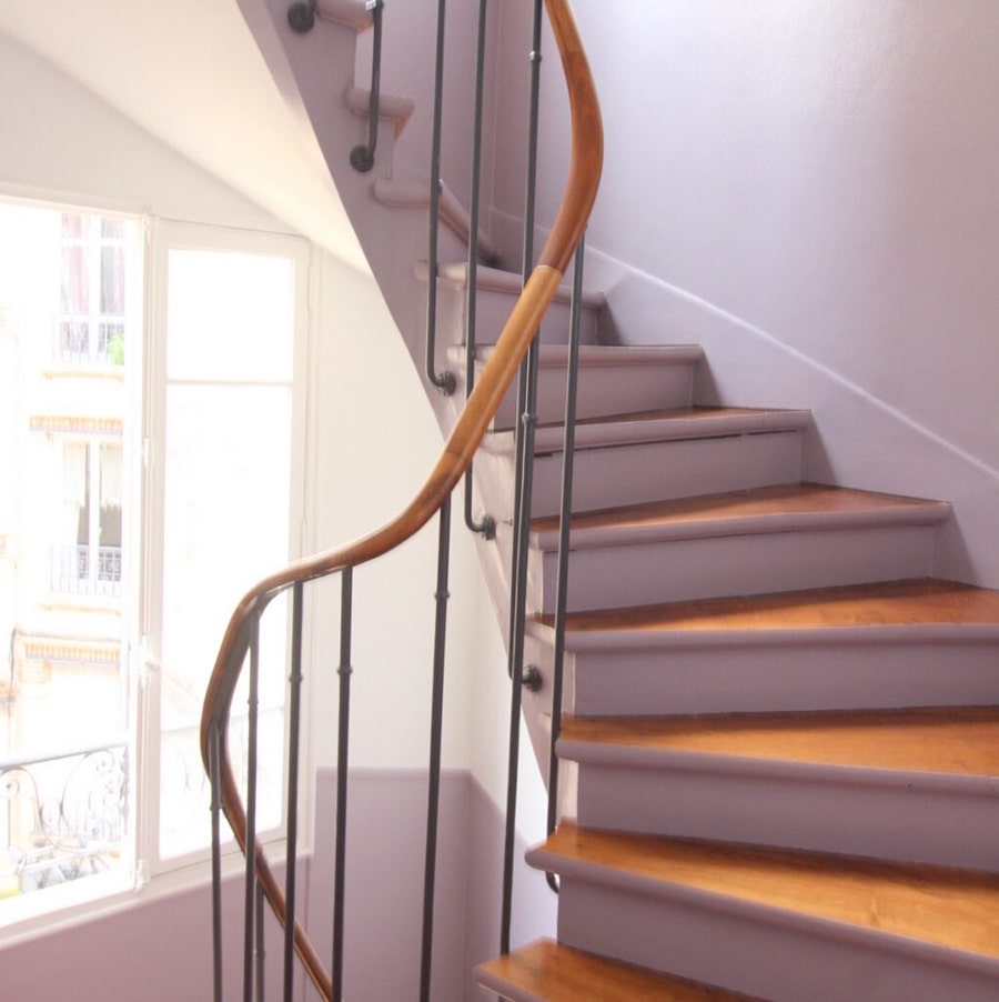 Escalier lumineux avec rambarde en bois et fer forgé, menant à un 2 pièces à Asnières, situé proche de la gare, proposé par Early Birds chasseurs immobiliers.