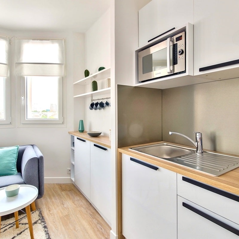 Cuisine moderne et équipée avec rangements, micro-ondes intégré, et évier design dans un 2 pièces à Asnières proche du métro, proposé par Early Birds chasseurs immobiliers.