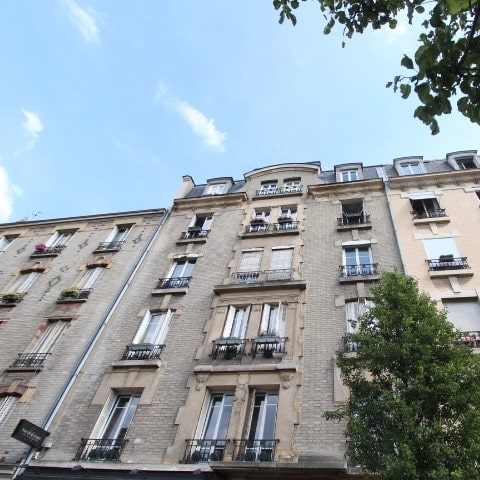 Façade d’un immeuble haussmannien situé aux Allées Gambetta à Clichy (92), caractérisé par des balcons en fer forgé et une architecture classique.