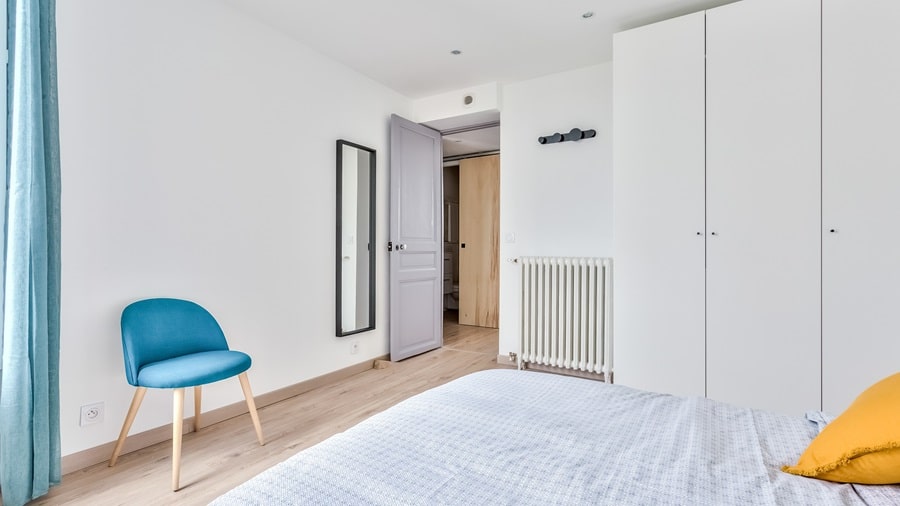 Chambre moderne avec grand placard intégré, design épuré et lumière naturelle dans un appartement situé à Colombes, idéal pour un investissement locatif