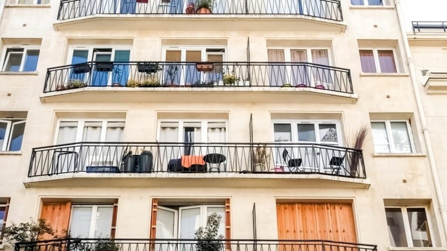 Façade d’un immeuble parisien dans le quartier d’Auteuil, avec des balcons fleuris et une architecture typique, idéale pour un investissement locatif de standing.