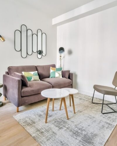 Salon lumineux d’un appartement clé en main à Auteuil, Paris 16, comprenant un canapé en velours marron, des fauteuils design, et une décoration moderne, parfait pour un investissement locatif haut de gamme.