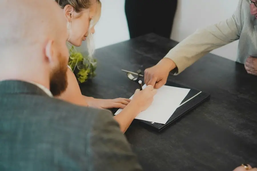 Signature d’un contrat immobilier avec conditions suspensives par un chasseur d’appartement à Paris.