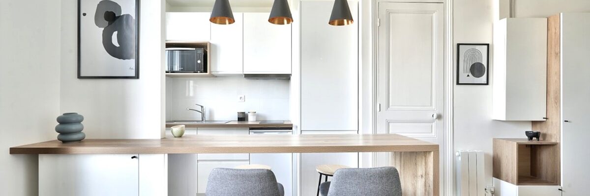 Cuisine ouverte rénovée avec îlot et espace repas, idéale pour un investissement locatif clé en main à Paris.