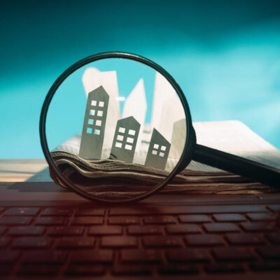 Vérification d’un appartement à distance, illustrée par une loupe observant des maisons symboliques.