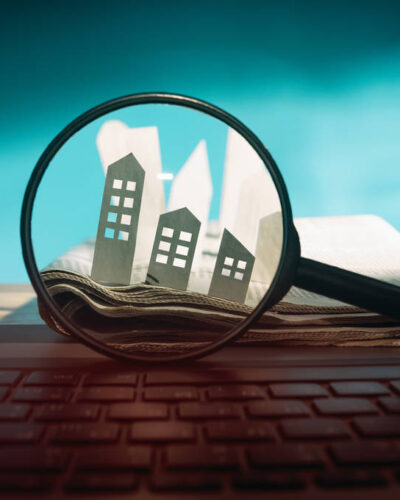 Vérification d’un appartement à distance, illustrée par une loupe observant des maisons symboliques.