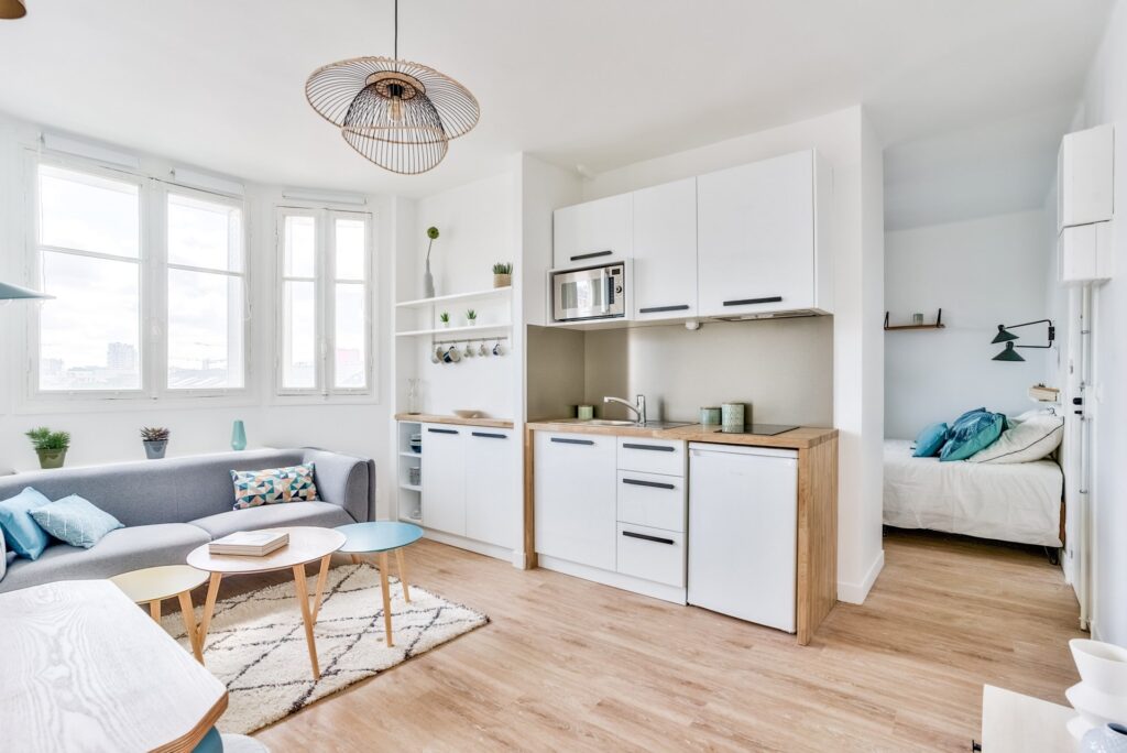 Intérieur moderne d'un studio meublé avec mur turquoise et parquet pour investissement locatif sécurisé dans le quartier des Batignolles Paris 17e