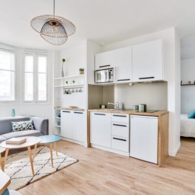 Intérieur moderne d'un studio meublé avec mur turquoise et parquet pour investissement locatif sécurisé dans le quartier des Batignolles Paris 17e