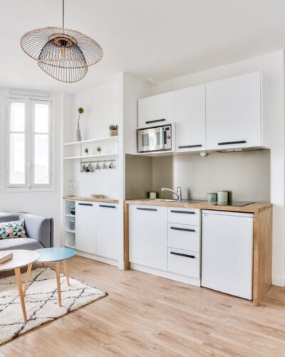 Intérieur moderne d'un studio meublé avec mur turquoise et parquet pour investissement locatif sécurisé dans le quartier des Batignolles Paris 17e