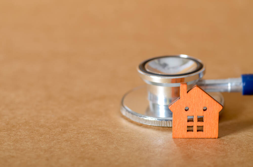 Stéthoscope et maison miniature symbolisant les vérifications techniques obligatoires avant l'achat d'un premier appartement à Paris