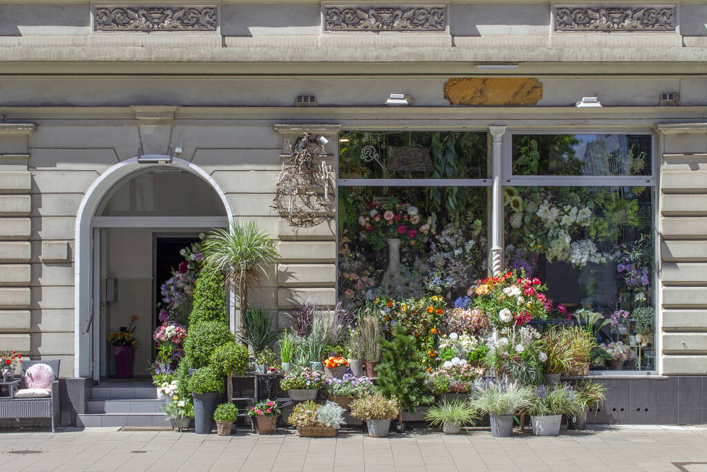 Boutique de fleurs en rez-de-chaussée d’un immeuble ancien parisien avec appartements aux étages