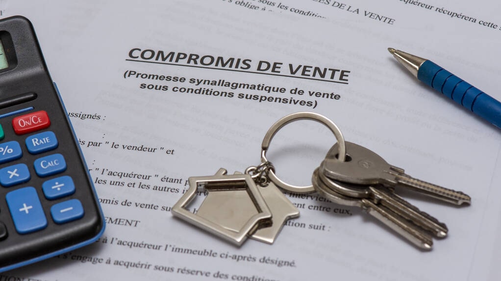 Document de compromis de vente immobilier avec clés et calculatrice, illustrant une promesse de vente sous conditions suspensives