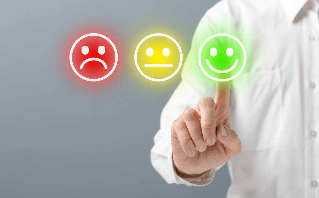 Main sélectionnant un indicateur de satisfaction positif, illustrant l’importance de la qualité de l’accompagnement dans un projet d’achat immobilier